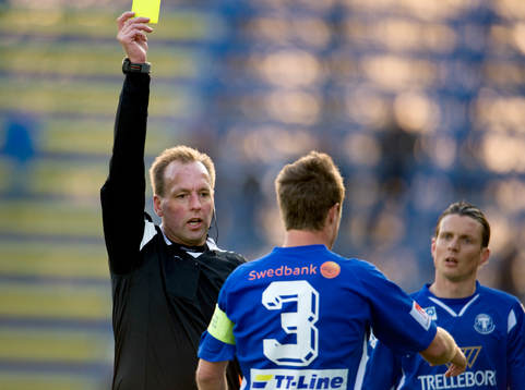 Håkan Jonasson, domare ger gult kort. Varning