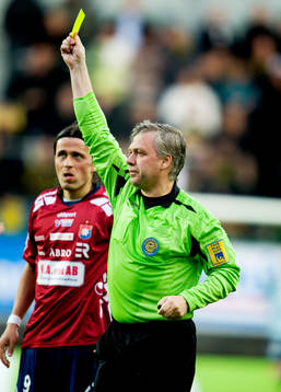 Åke Andreasson, domare ger gult kort, varning