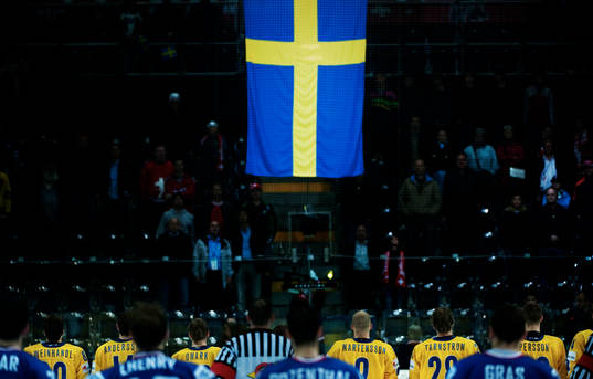 De svenska spelarna ser Sveriges flagga hissas