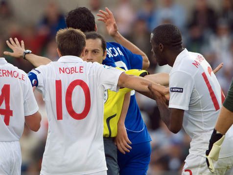 Cüneyt Cakir, domare, i diskussion med Mark Noble, England