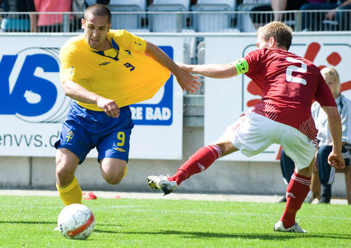 Målskytten Emir Bajrami blir dragen i tröjan av Anders