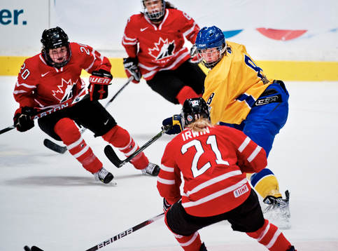 Erika Holst, Sverige, är omringad av kanadensiska spelare