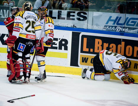 Simon Bertilsson, Brynäs, får en tackling av Fredrik