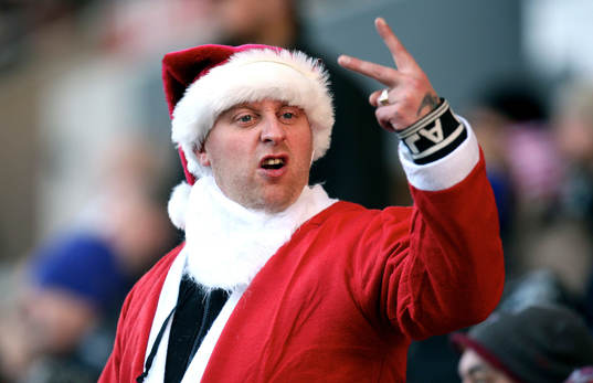 En bråkig supporter utklädd till jultomte gör fula tecken