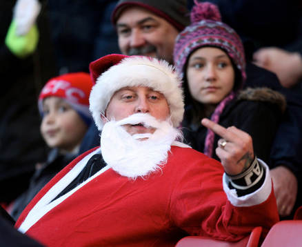 En bråkig supporter utklädd till jultomte gör fula tecken