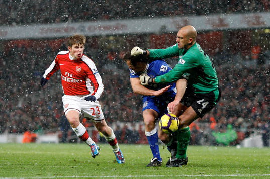 Lucas Neill dundrar in i Tim Howard, målvakt, Everton.