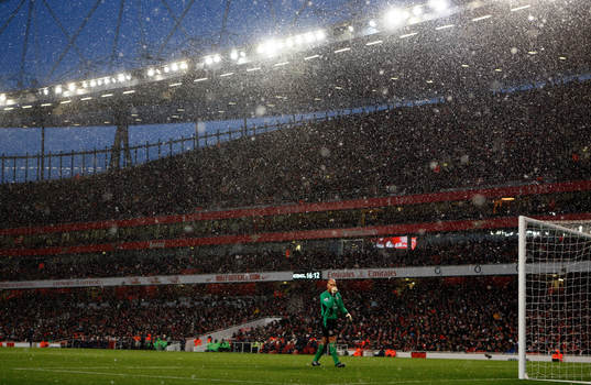 Snön faller över Emirates Stadium och Tim Howard,