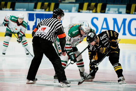 Niclas Johansson, domare, släpper pucken när Jeremy