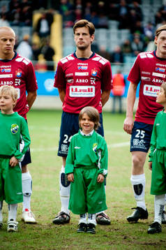 Inför match, maskot med lite för stora kläder framför