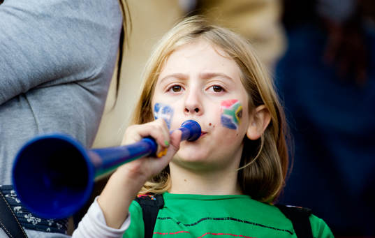 En flicka blåser i vuvuzela
