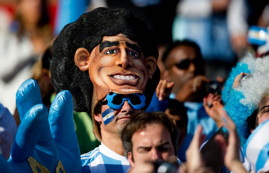 En argentinsk supporter med Maradona huvudbonad