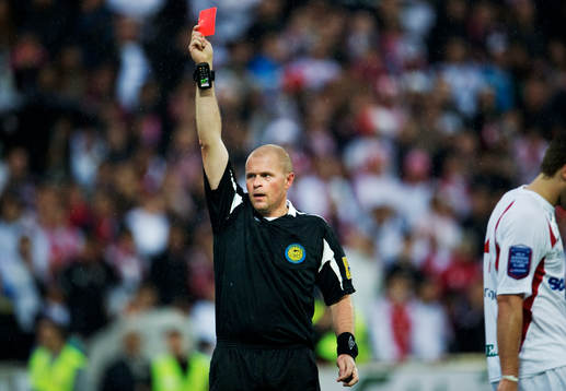 Mattias Nyman, domare, delar ut ett rött kort
