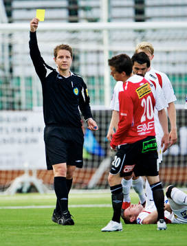 Martin Strömbergsson, domare, delar ut ett gult kort