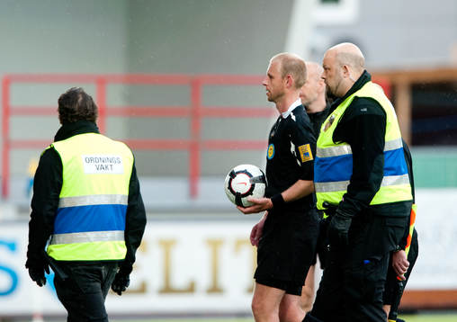 Domare Fredrik Lundberg eskorteras av planen