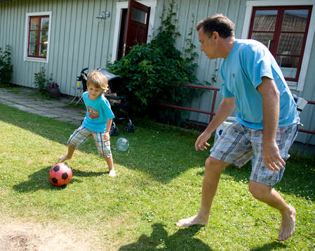 Mikael Pernfors och sonen Figge sparkar fotboll utanför