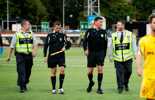 Antti Kanerva, domare, får vakteskort från arenan
