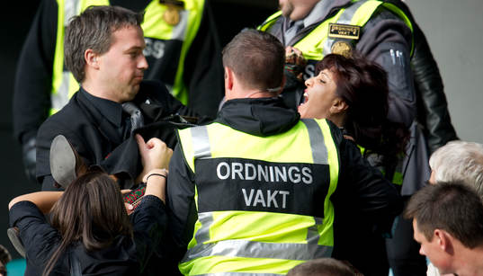 En kvinna vill inte lämna arenan och bärs ut