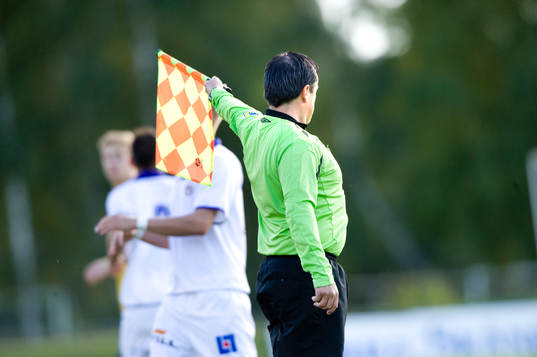 Assisterande domare vinkar för offside, flagga, linjeflagga