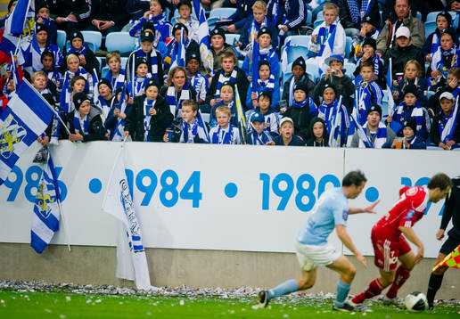 Young fellows på läktaren och utanför med flaggor