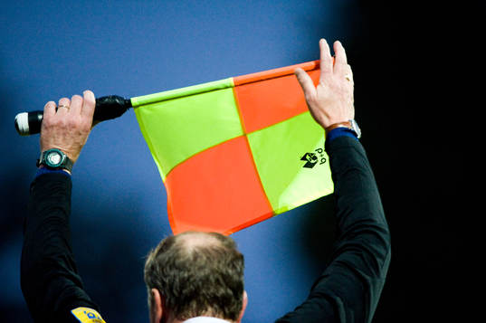 Byte, assisterande domare med flagga signalerar för byte