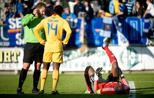Domaren Martin Strömbergsson tittar till Pa Dembo Touray,
