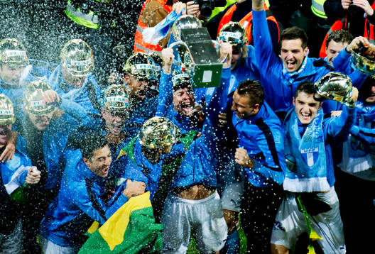 Malmö FF:s lagkapten lyfter pokalen i champagne regnet.