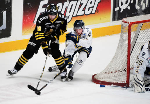 Adam Almquist, HV71, försöker stoppa Kent McDonell, AIK