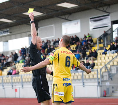 Fredrik Lundberg, domare, visar gult kort för Jacob