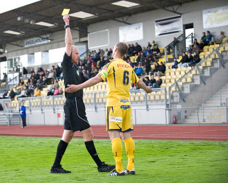 Fredrik Lundberg, domare visar gult kort för Jacob