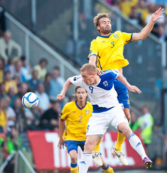 Olof Mellberg, Sverige, hoppar högt på Mikael Forssell,