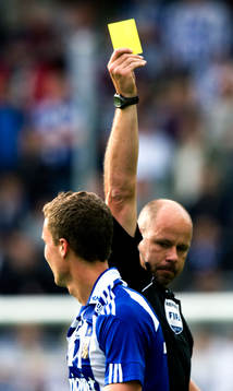 Martin Hansson, domare delar ut gult kort, varning