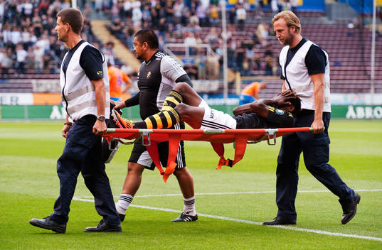 Mohamed Bangura, AIK, bärs ut på bår. Skada