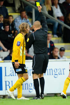 Tobias Grahn, Mjällby, får gult kort av domare Michael