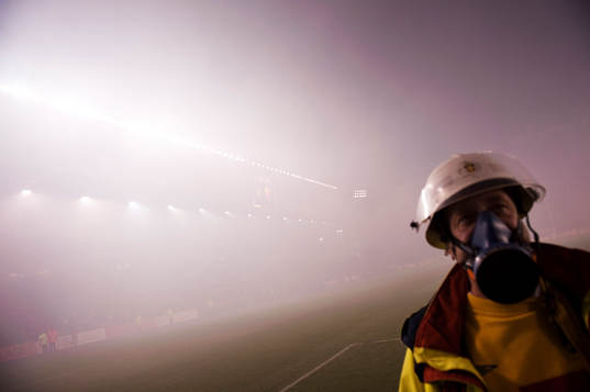En brandman står ute på plan när matchen avbrutits.