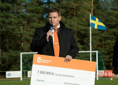 Urban Widman, från Hässleholms kommun lämar en check på