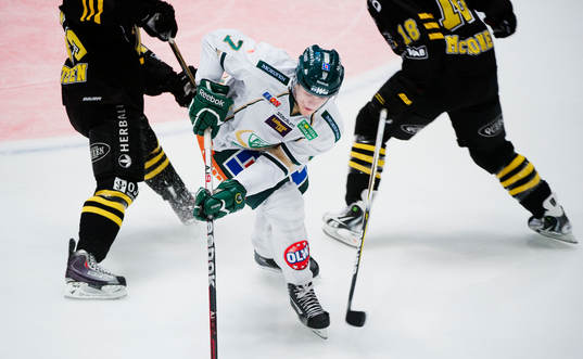 Oscar Klefbom, Färjestad, tar sig mellan två AIK-spelare