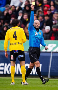Michael Lerjéus, domare, delar ut ett gult kort till