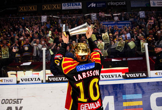 Johan Larsson, Brynäs, håller upp pokalen mot publiken.