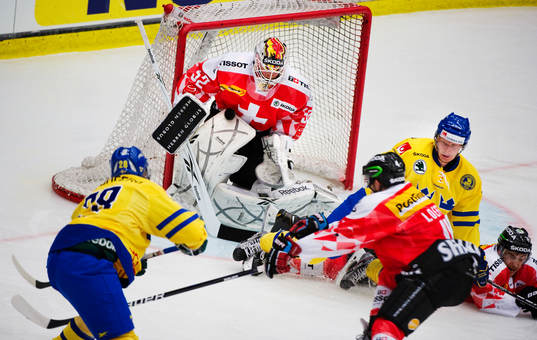 Jonas Brodin och Simon Hjalmarsson, Sverige, får in pucken