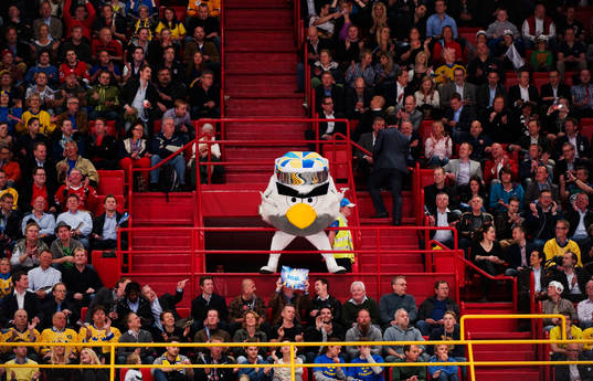 Maskoten Hockey Bird eldar på publiken. Maskot,