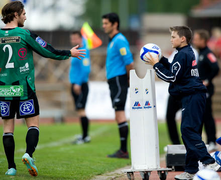 Bollkalle ger bollen till spelare för inkast, assisterande
