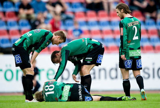 Skadad spelare, lagkamrater skyndar till. Skada