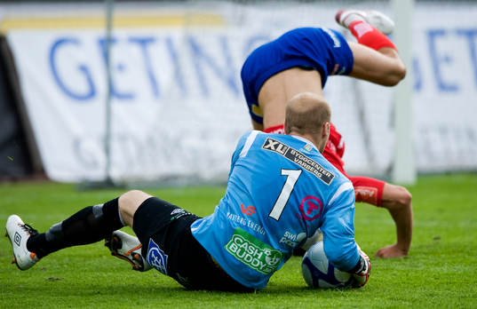 Målvakt tar bollen, utespelaren stupar