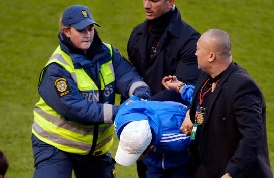En supporter springer in på planen. Ordningsvakt