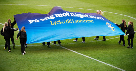 En flagga med texten "På väg mot något stort - Lycka