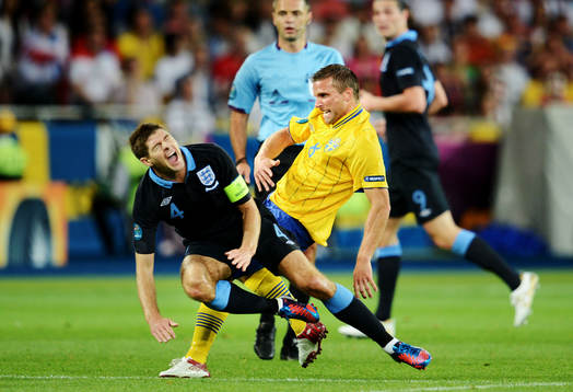 Steven Gerrard, England, blir hårt tacklad av Anders