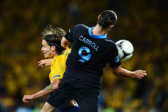 Mikael Lustig, Sverige, i en luftduell med Andy Carroll,