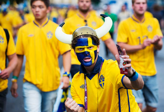 Ett svenskt fan, supporter med vikingahjälm på väg mot
