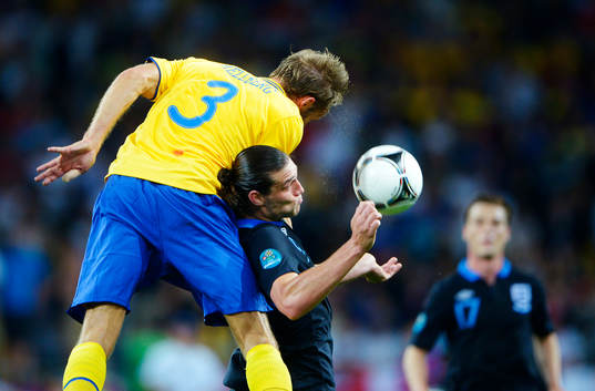 Olof Mellberg, Sverige, i en nickduell med Andy Carroll,