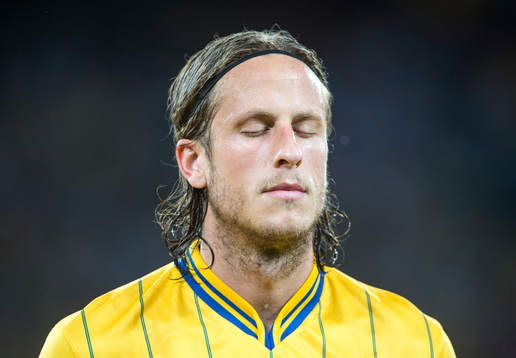 Jonas Olsson blundar och lyssnar på nationalsången